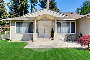 Bright covered porch with columns and sitting area with table set