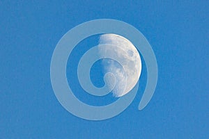 Bright crescent moon over the completely blue sky.