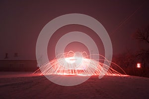 Bright crimson sparks in fog, steel wool photography,
