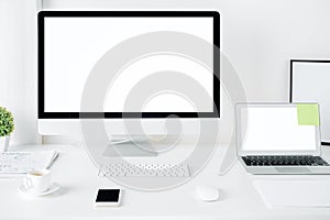 Bright designer desktop with computer and laptop