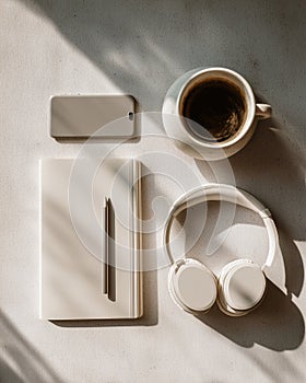 Coffee, headphones, notebook and smartphone on bright desk, AI generated