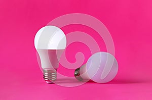 Bright and dim light bulbs on magenta background. Concept of occupational burnout