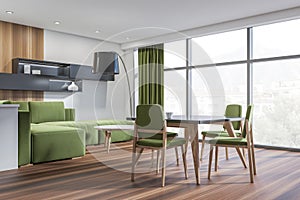 Bright dining room interior with green sofa, four chair, lamp