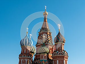 The bright domes of St. Basil`s Cathedral against the blue sky. Red Square, Moscow, Russia