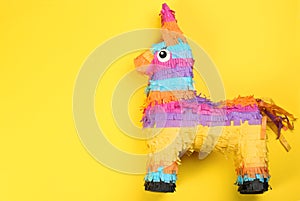 Bright donkey pinata on yellow background, top view. Space for text photo