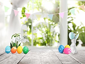Bright Easter eggs, flowers and bunny figure on table