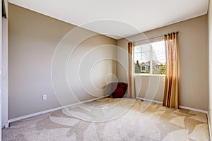Bright empty room with one window, carpet floor and ivory walls