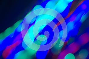 Bright festive multicolored circles and lines in motion. Defocused abstract colorful lights