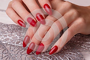 Bright festive red manicure on female hands. Nails design