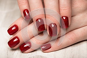 Bright festive red manicure on female hands. Nails design