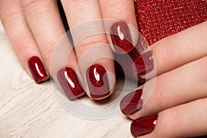 Bright festive red manicure on female hands. Nails design