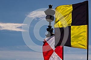 Bright flags of the international maritime code of signals near the lantern on the bridge.