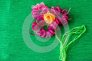 Bright flower made of threads on green background