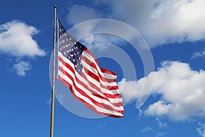 bright flowing waving american flag sunny day white clouds
