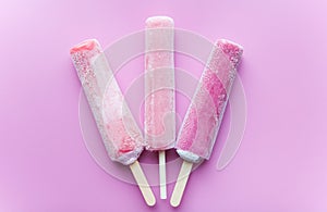 Bright fruit ice cream on a stick on a pink background. Frozen fruit ice. Summer mood. Cooling dessert in hot weather. Favorite de