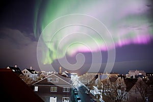 Bright full sky pink aurora borealis over Reykjavik Iceland