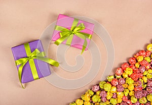 Bright gift boxes and colorful caramel popcorn on a paper background. Celebratory concept.