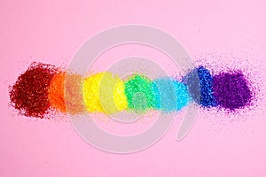 Bright glitters on pink background. Rainbow colors