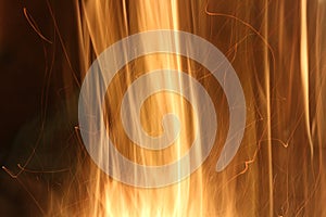 Bright golden orange flames against black background with copy space