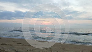 Bright golden sunset on the beach, the waves on the sand, shells. Ocean, clear. Golden sunlight reflecting on a beach. Sun shining