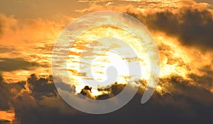 Bright Golden Yellow Orange Sunlight from Dark Grey Clouds in Sky - Warm Skyscape - Heat and Solar Energy photo