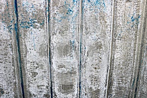 A bright gray saturated relief texture of a beautifully painted metal surface with vertical stripes and shabby peeling paint