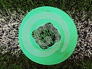 Bright green blue plastic cone on painted white line. Plastic football green turf playground with grind black rubber