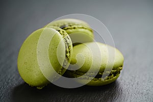 Bright green macarons on slate background