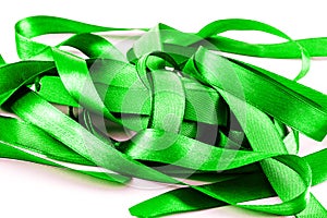 Bright green tangled satin ribbons on white.