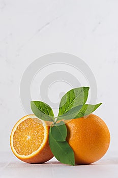 Bright group oranges with fresh green leaf and piece on soft light white modern background, vertical.