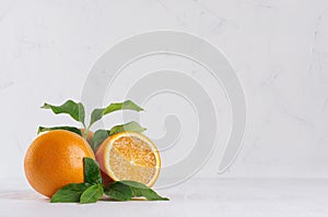 Bright group oranges with fresh green leaf and piece on soft light white modern interior.