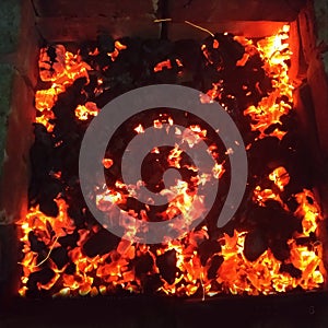 Bright hot coals and burning woods in bbq grill pit. glowing and flaming charcoal barbecue red fire and ash