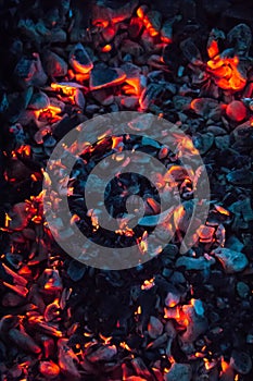 Bright hot coals and burning woods in bbq grill pit. Glowing and flaming charcoal, barbecue, red fire and ash. Weekend background.