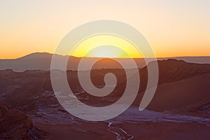 Bright hues of sunset over distant mountains ridge in Atacama Desert, Chile, South America.