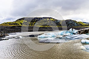 Bright ice burgs against the brown glacier fed lake at Hoffell Glacier