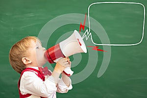 Bright idea! Happy child student against green chalkboard