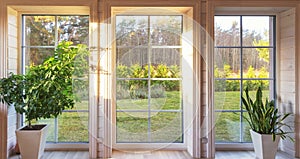 Bright interior of the room in wooden house with a large window overlooking the autumn courtyard. Home and garden, fall