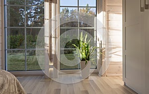 Bright interior of the room in wooden house with a large window overlooking the autumn courtyard. Home and garden, fall