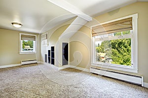 Bright ivory room with vaulted ceiling and built-in shelves. Empty house interior