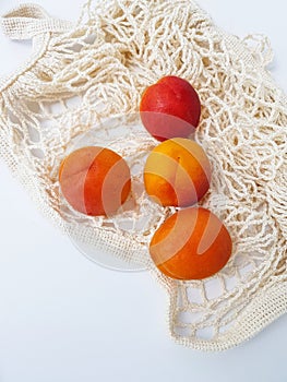 Bright juicy apricots in a cotton wicker bag.