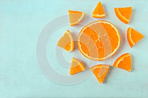 Bright juicy orange slices in the shape of a sun on a light back