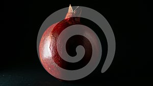 Bright juicy pomegranate fruit, black background , close-up