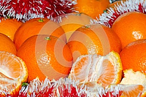 Bright juicy tangerines in a Christmas shiny tinsel, the concept