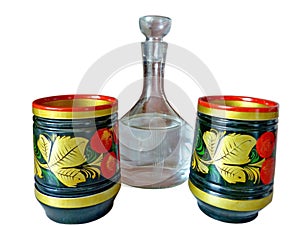 Bright Khokhloma stacks and a decanter of vodka, isolated on a white background. Khokhloma is an old Russian folk craft