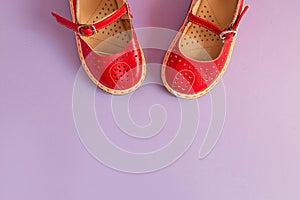 Bright kids shoes on lilac background with copyspace. Baby clothes concept. Top view, flat lay