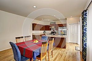 Bright kitchen and dining room interior with white walls and hardwood floor.