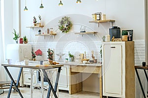 Bright kitchen interior with Christmas decor and Christmas wreath. Kitchenware