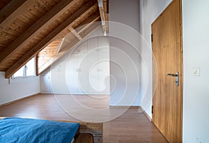 Bright light modern simple master bedroom with wooden parquet floors and designer closet and traditional wooden beam bed under sla