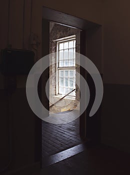 Bright light from stairwell window, seen from a dark doorway.