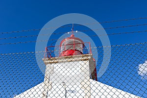 Bright Lighthouse against Blue Sky Background
